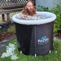 A man with a stoic expression and a long beard sits in an ice bath